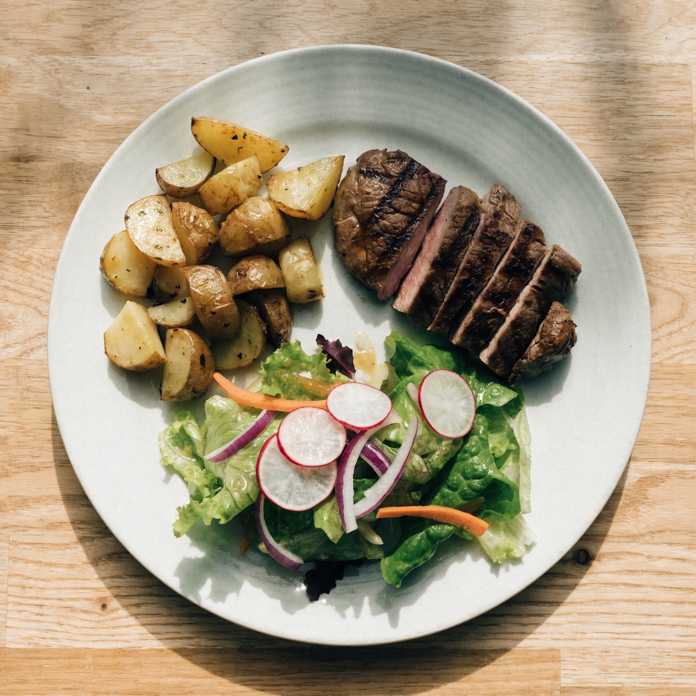 Plato balanceado con proteína, papas y ensalada